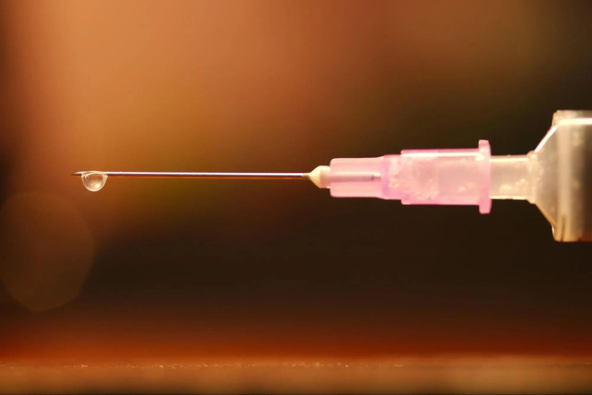 Close-up of an insulin syringe needle with a single medication droplet